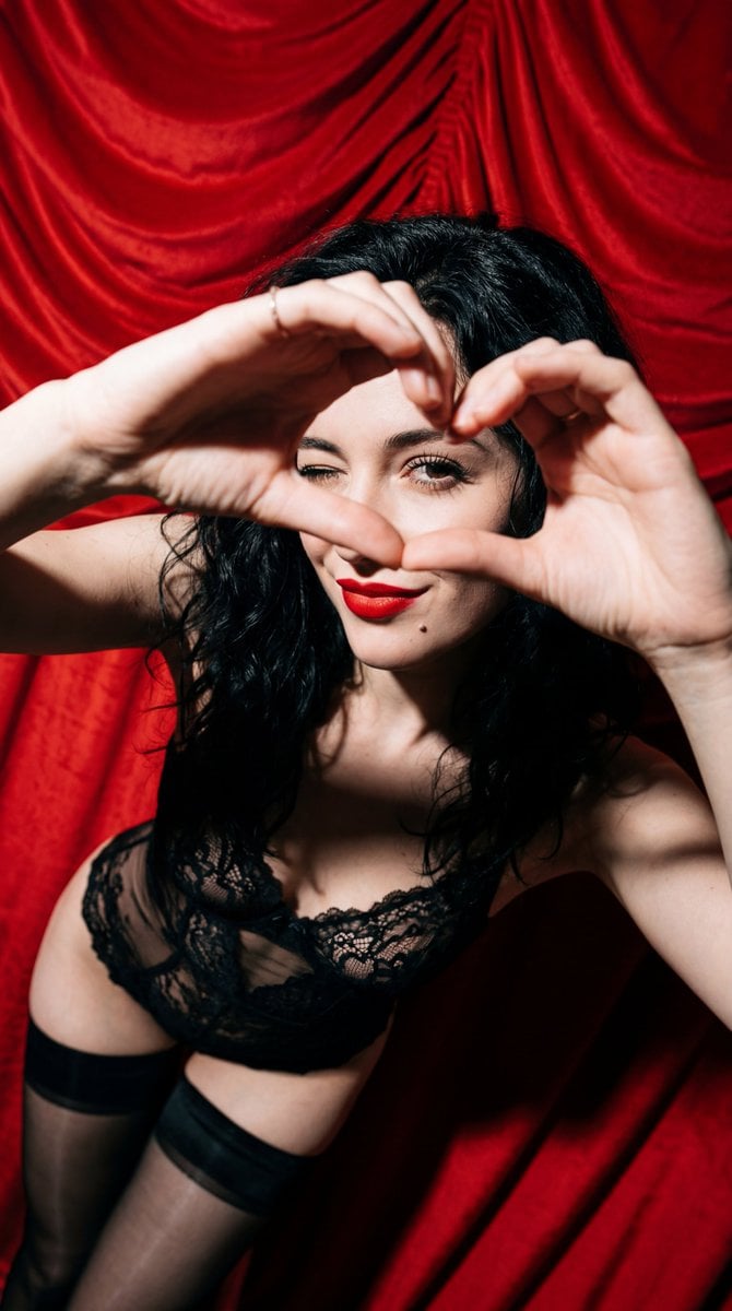 Subject: A young woman with wavy, tousled jet-black hair. She has a f…