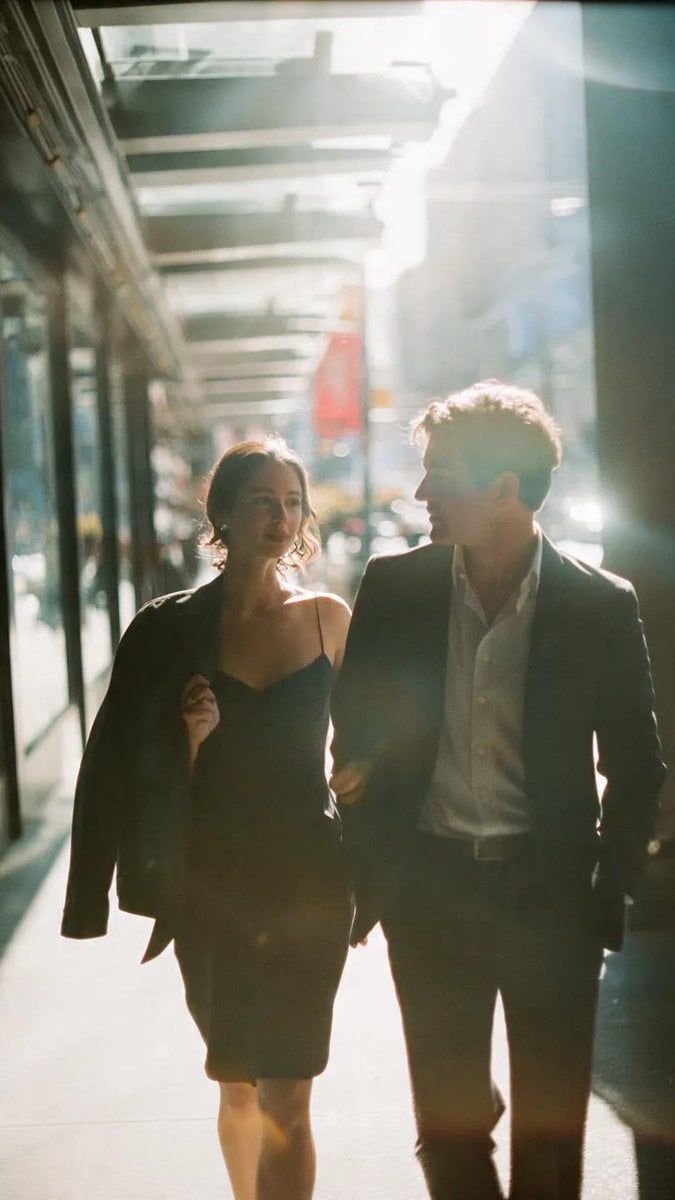 A cinematic candid medium shot portrait of a man and a woman walking…