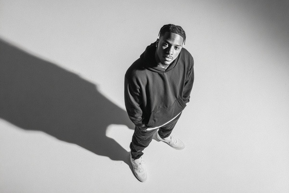 A [subject] photographed from a 35-degree overhead angle, standing alone in an off-white studio void, with a…