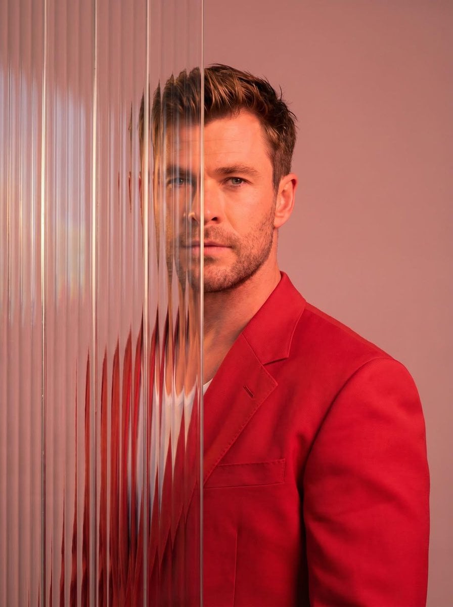 A striking editorial portrait photograph of a person wearing a red bl…