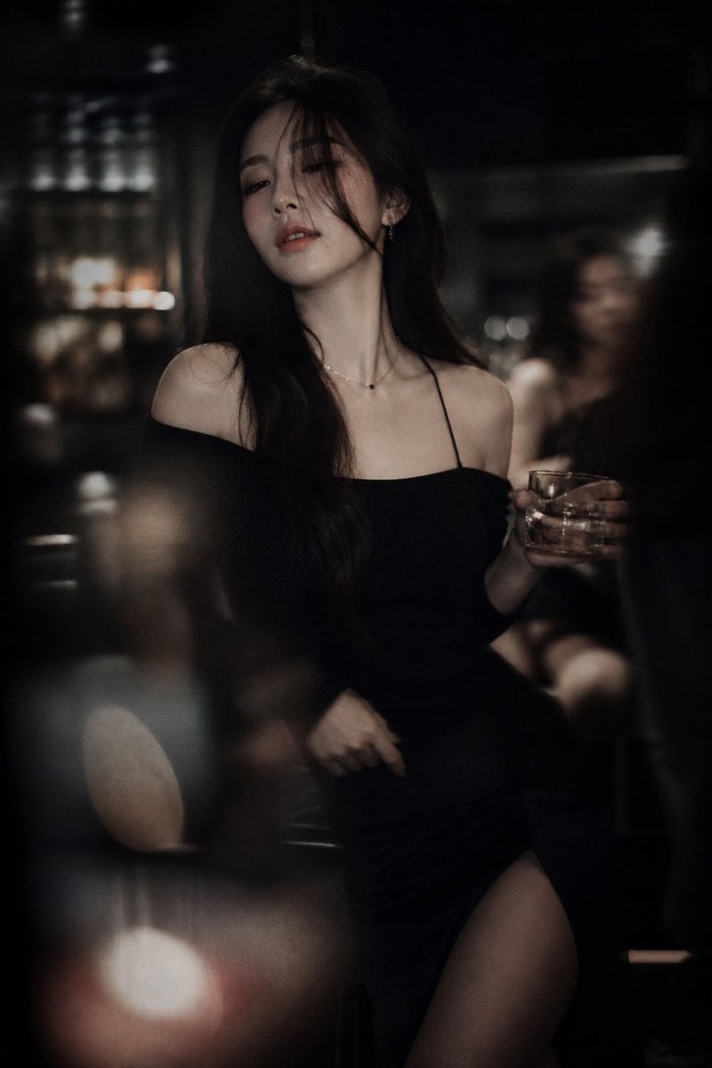 Low-light cinematic portrait, telephoto lens compression, shallow depth of field, intentional soft focus and…