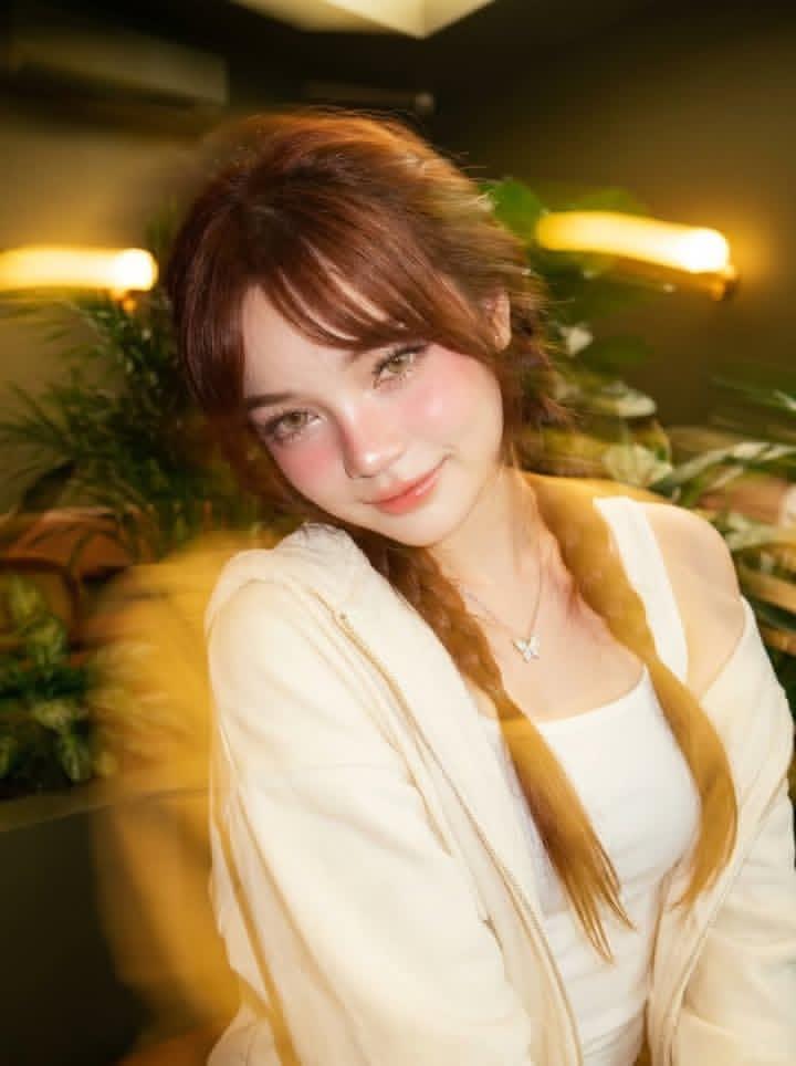 Ultra-realistic portrait of a beautiful young woman sitting in a cozy…